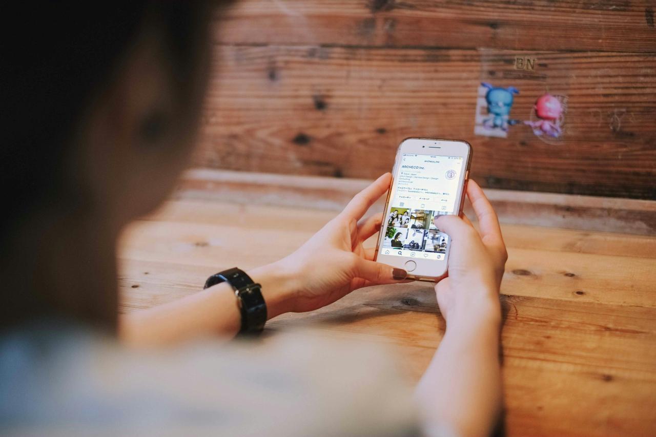 foto fokus dangkal orang yang menggunakan iPhone 6 perak