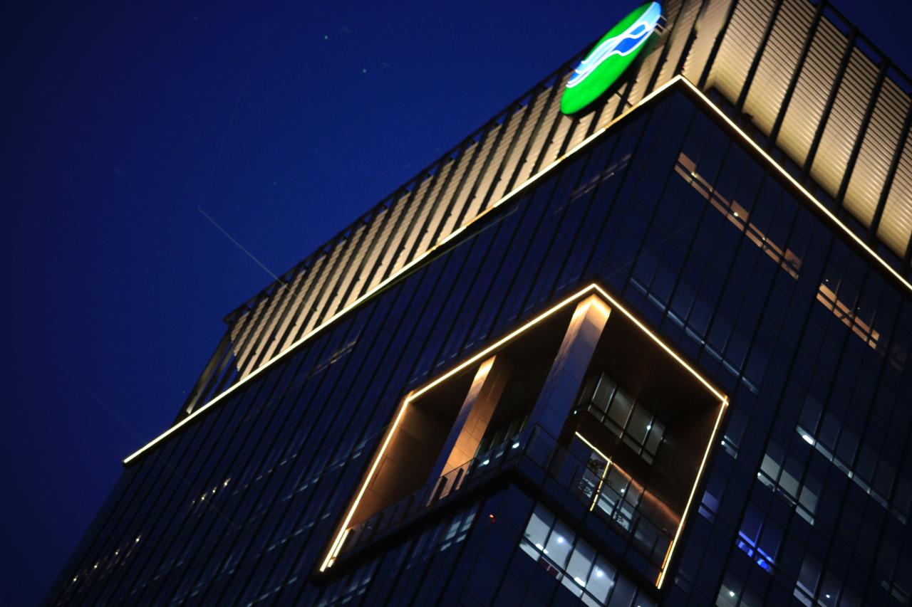 Bangunan modern dengan logo yang menyala di malam hari