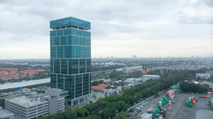 Gedung pencakar langit kaca modern di lanskap kota yang luas.